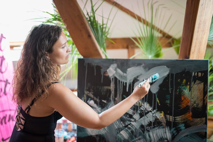 A Woman In Black Lingerie Painting On The Canvass