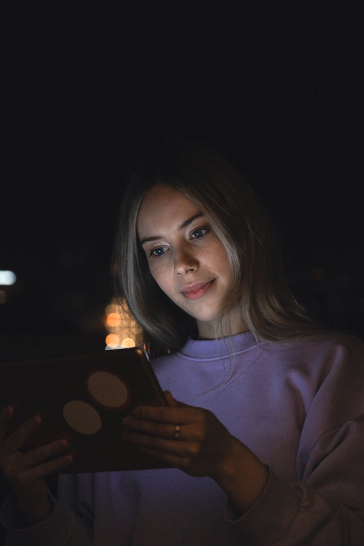 Young Woman Watching Tablet In Dark