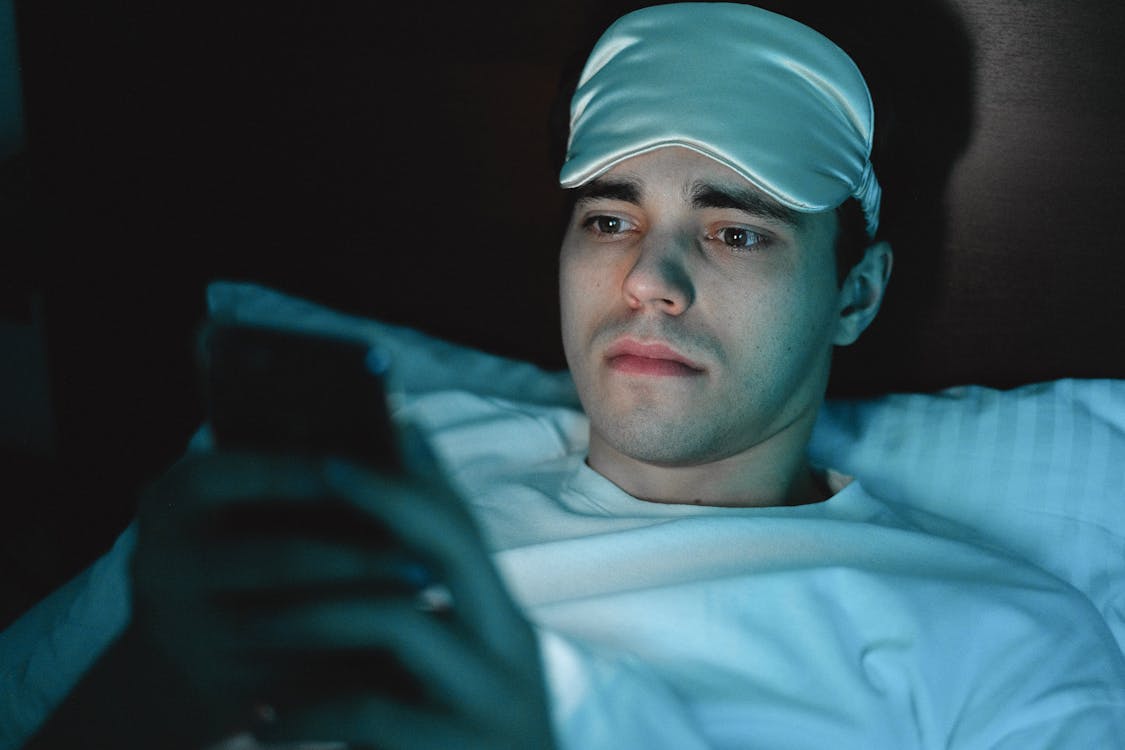 Free A Man in White Shirt with Sleeping Mask on His Head Stock Photo