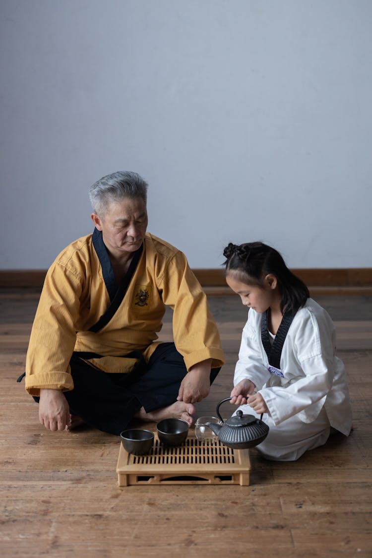 Child Pouring Tea On Cups