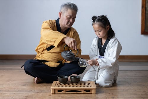 Free Senior Men and a Young Girl at a Tea Ceremony Stock Photo