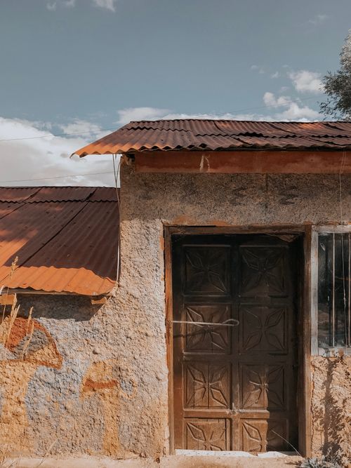 Free A rustic abandoned house with a wooden door and rusted roof in Gürpınar, Van, Türkiye, showcasing vintage architecture. Stock Photo