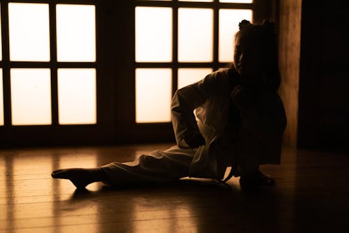 Free Young Girl In Karate Uniform Stretching Her Leg Stock Photo