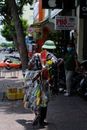 Man in Green Shirt and White Hat Carrying Plastic Bags