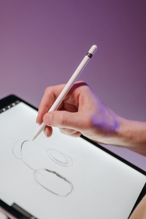 A Person Drawing on a Tablet 