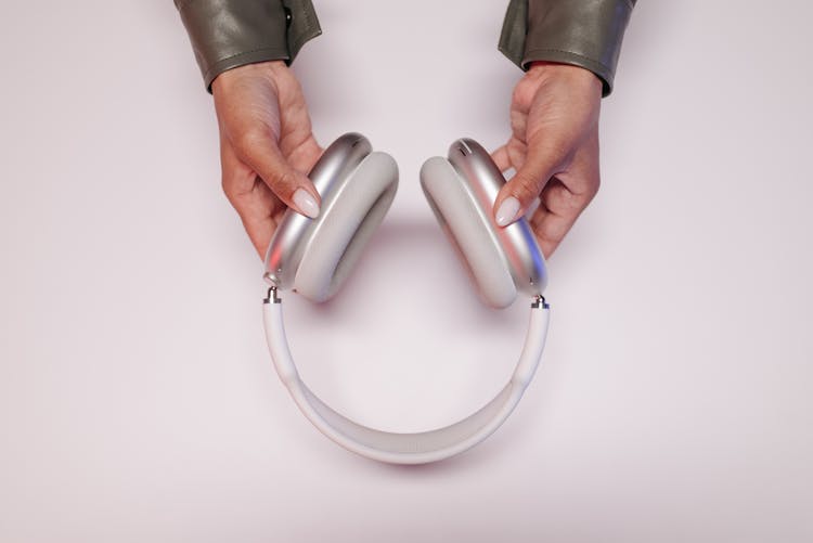 Person Holding A White Headphones