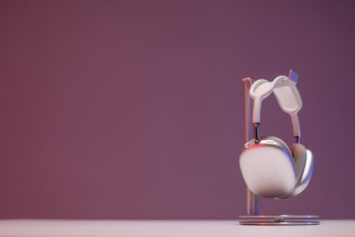 Free Stylish wireless headphones on a sleek stand against a purple background, perfect for audio tech promotions. Stock Photo
