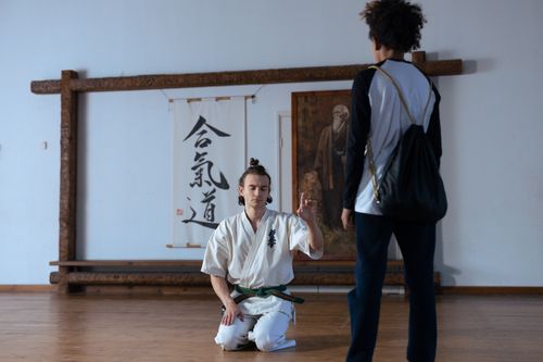 Free A man in a martial arts uniform kneels in meditation during training. Stock Photo
