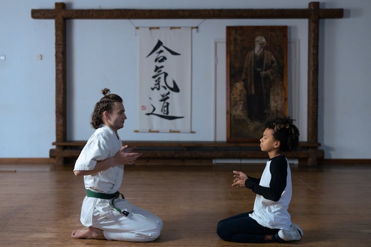 A Man And A Boy Kneeling On The Wooden Floor