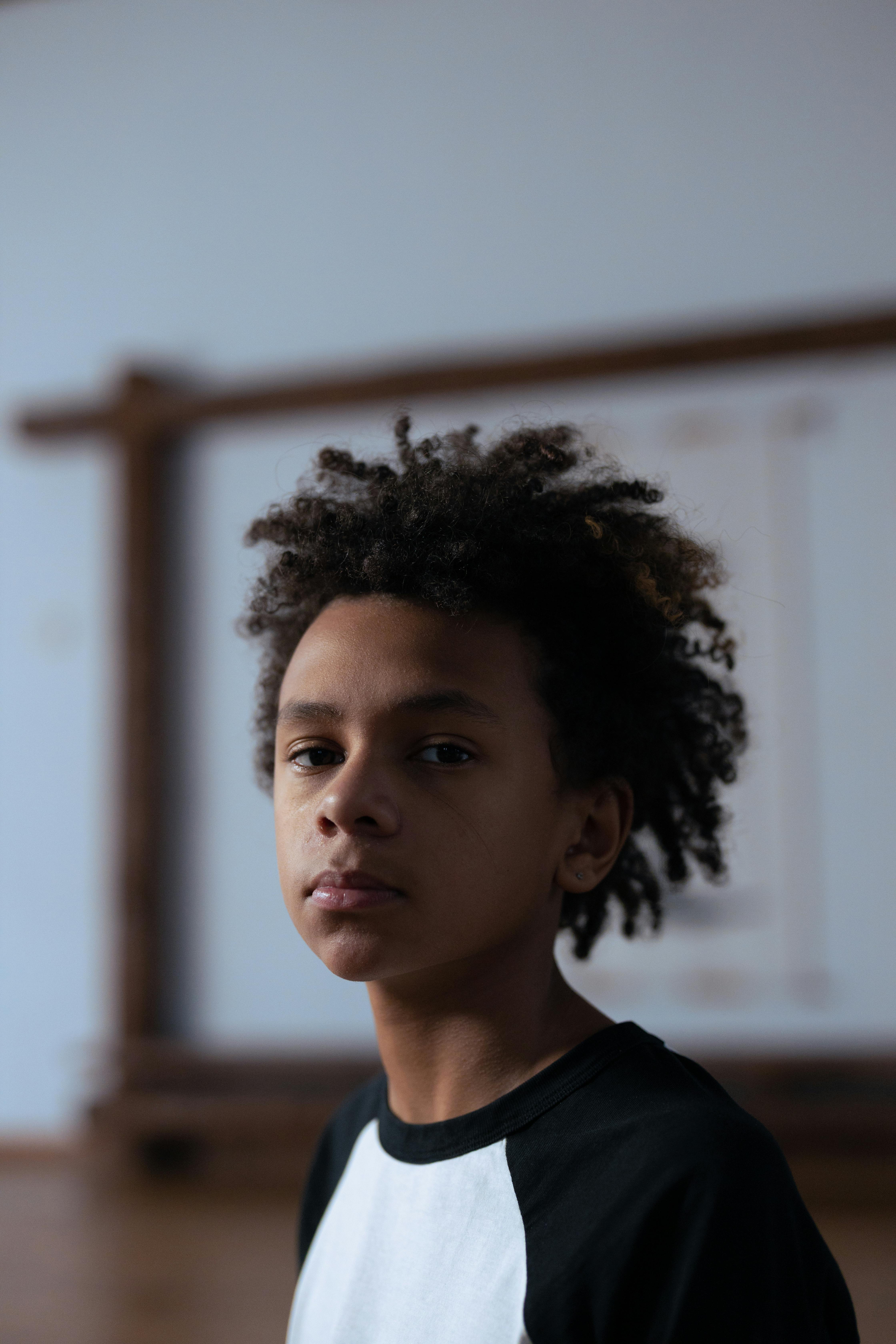 Selective Focus Shot of a Boy With Curly Hair Looking at The Camera · Free  Stock Photo