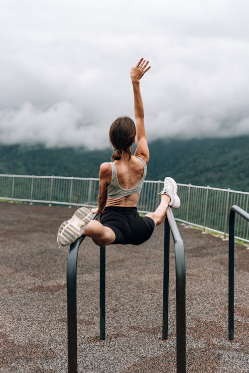 Free Woman Doing Balancing Exercise on Bars Stock Photo