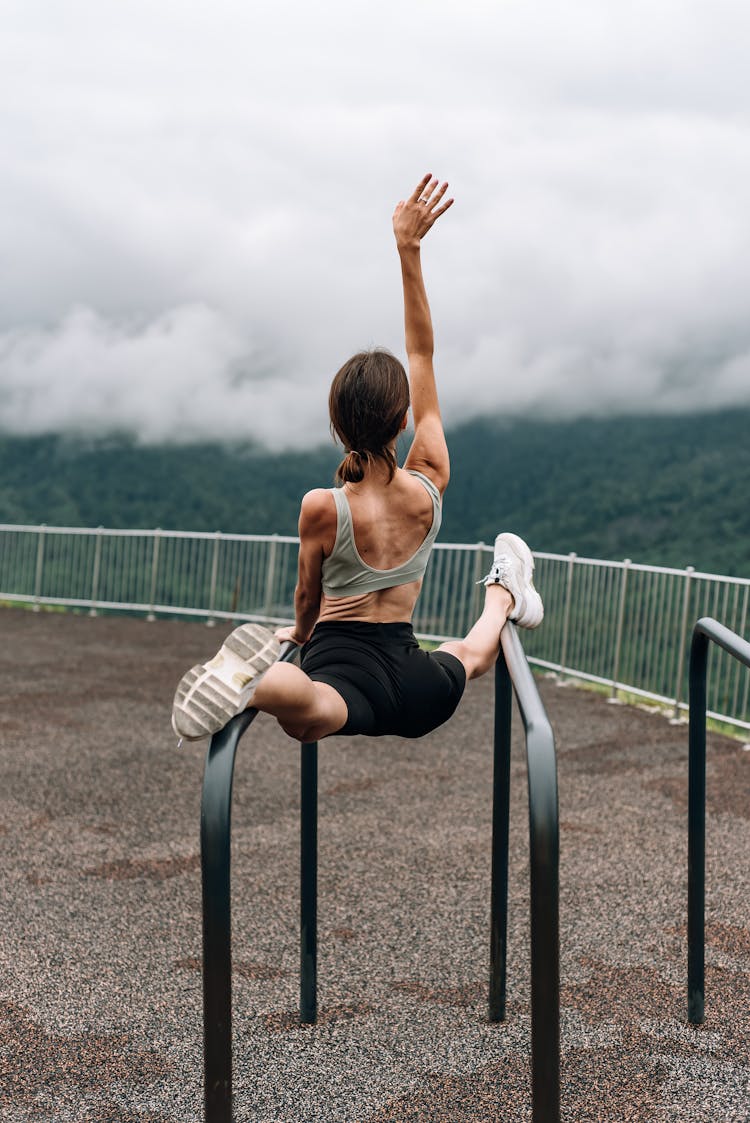 Woman Doing Balancing Exercise On Bars