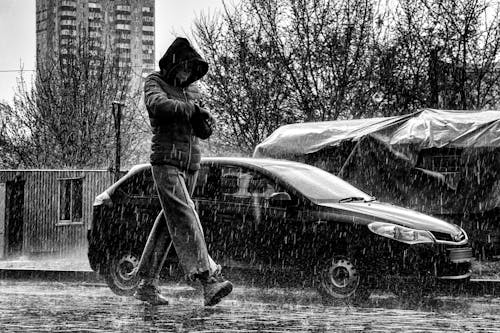 Man in Hoodie Jacket Walking on the Street on a Rainy Day