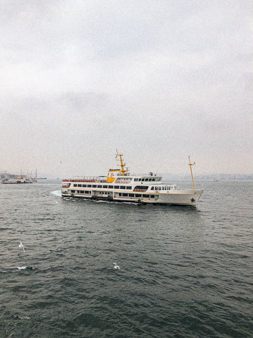 Free White and Yellow Ship on Sea Under White Sky Stock Photo