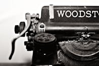 特写镜头展示了古董伍德斯托克打字机，突出了其经典的金属机械结构
