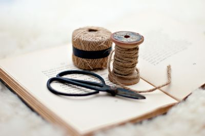 Scissors and twine resting on a cloth-bound book. Photo by Eneida Nieves on Pexels