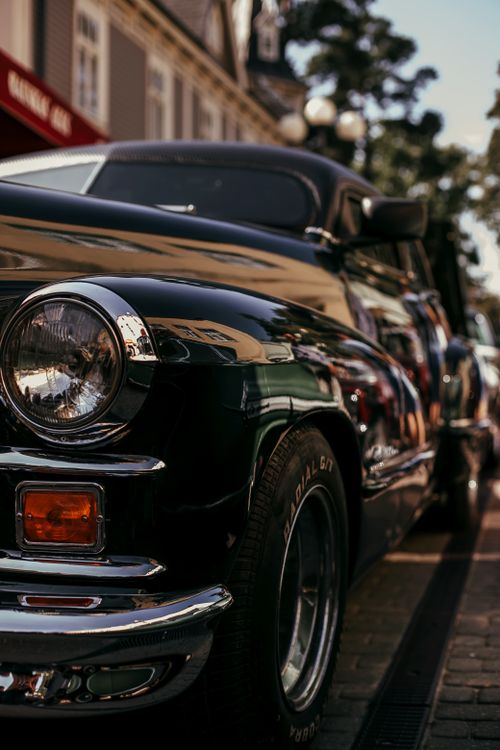 Free Close-up of a vintage car parked on a city street, showcasing its classic design. Stock Photo
