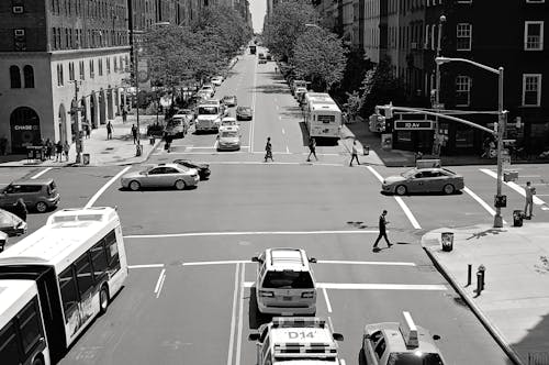 Greyscale Photo of Car and People on Streets