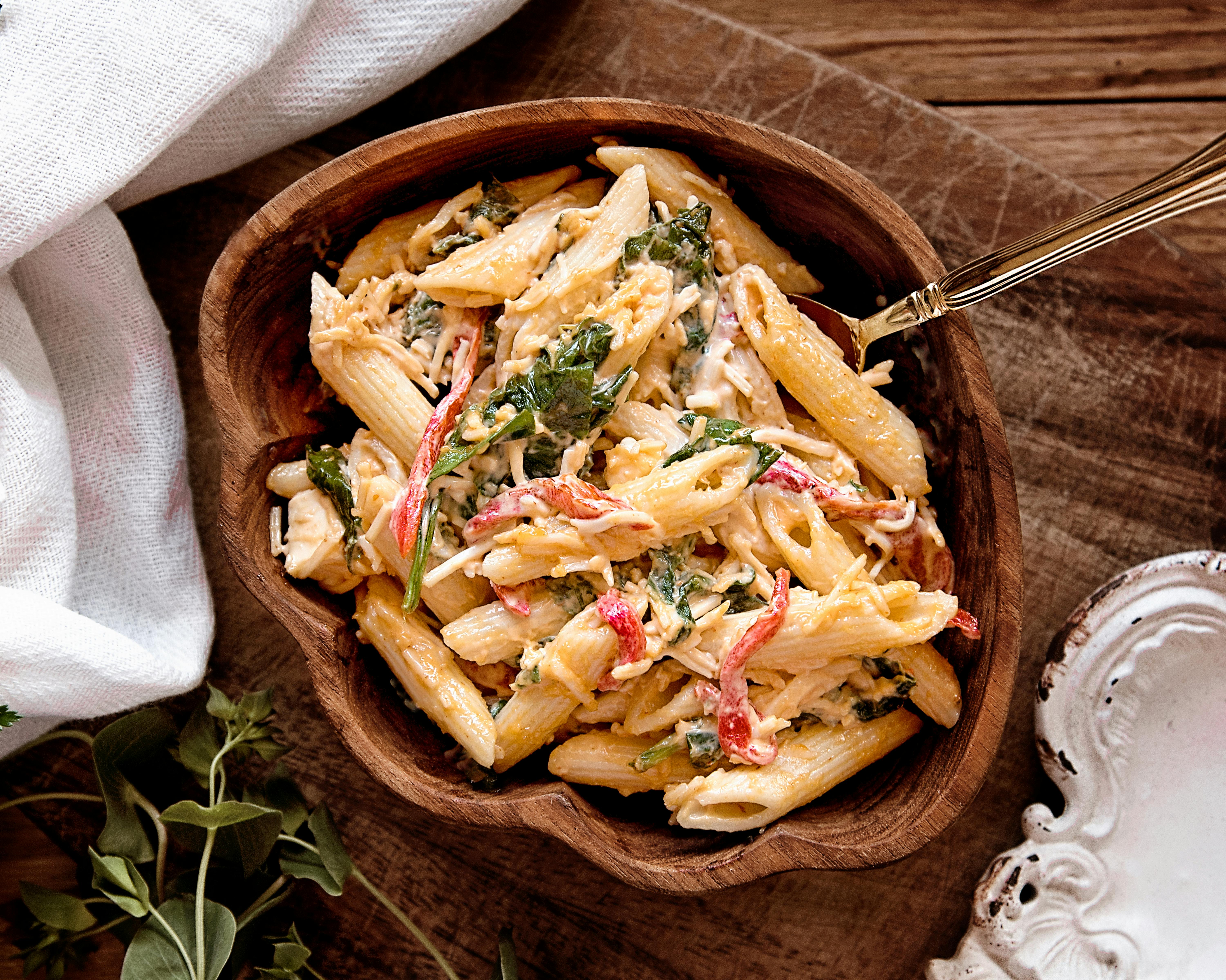 cooked pasta on brown wooden bowl