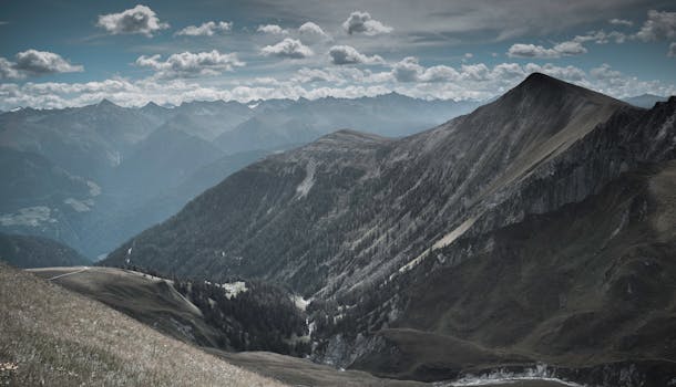 Breathtaking view of a mountainous landscape with cloudy skies and rugged peaks.