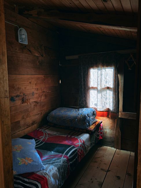 Rustic wooden cabin bedroom interior with natural light in Rize, Türkiye.