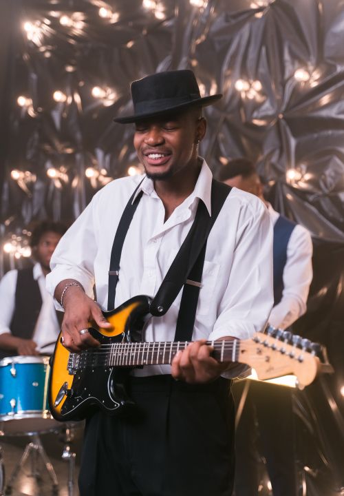 Free Portrait of a musician playing electric guitar at a vibrant live performance. Stock Photo
