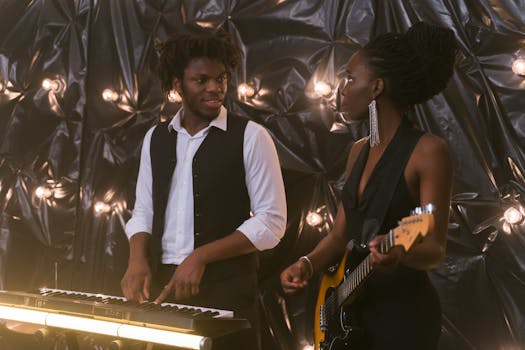 A male pianist and female guitarist perform together in a stylish indoor setting.