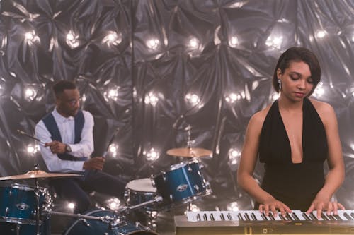 Woman Playing Piano and Man on the Drum Set