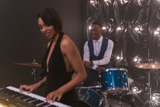 Energetic live music performance featuring a pianist and drummer in a studio setting.