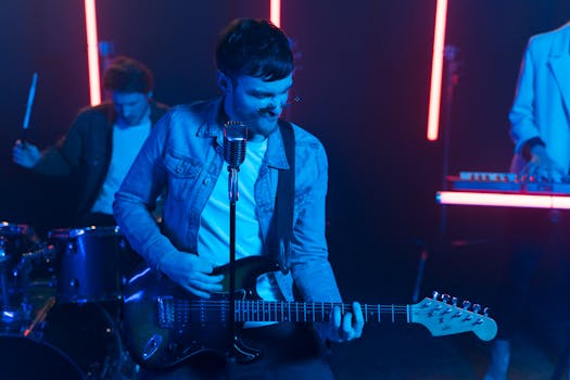 Energetic music performance featuring a guitarist under vibrant neon lights.