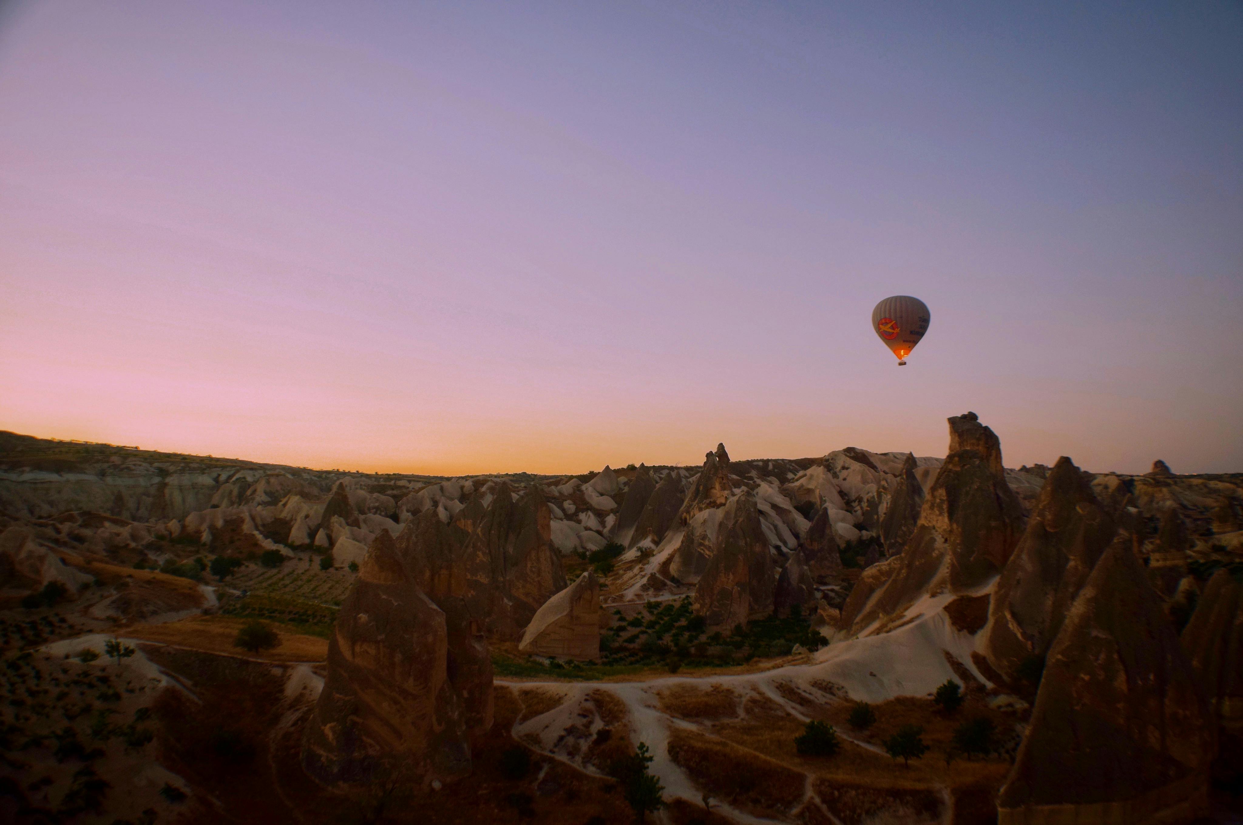 黄昏时分，热气球飞过卡帕多西亚独特的岩层，天空一片宁静
