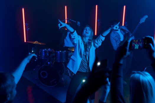 Exciting band performing live with vibrant lighting and engaging crowd in a nightclub.