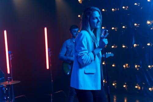 Close-Up Shot of a Woman in White Blazer Singing