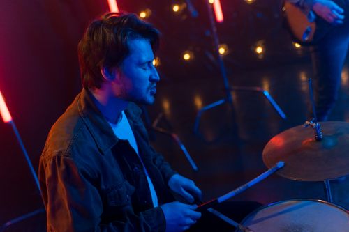 Free A man playing drums with colorful neon lights and bokeh background. Stock Photo