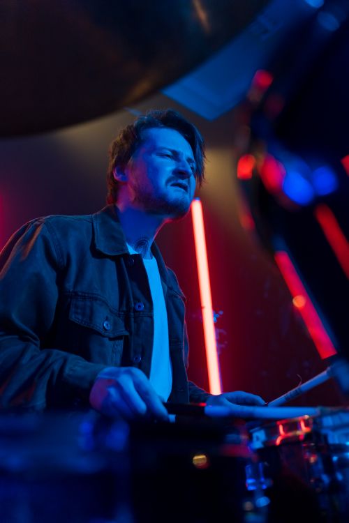 Free Energetic drummer passionately playing live music at a vibrant concert. Stock Photo