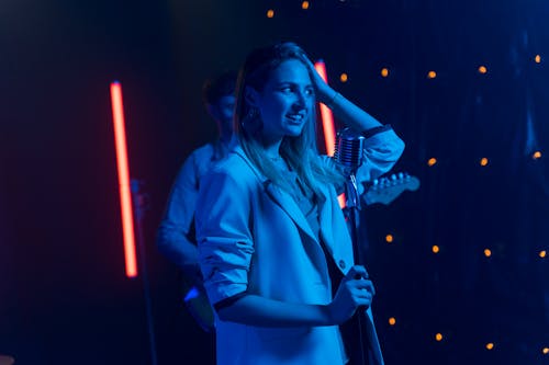 A Beautiful Woman Singing in front of the Microphone