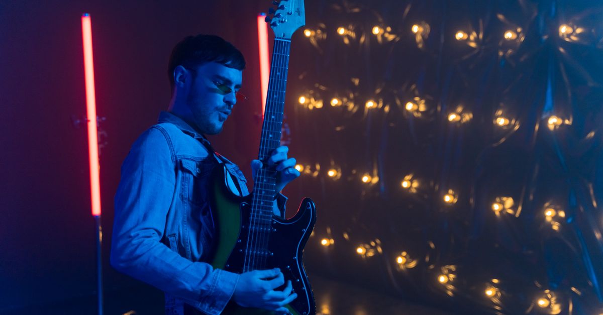 Jesus Jones band performing with a 1990s backdrop and neon lights