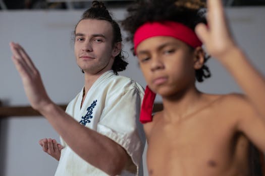 Martial arts session featuring a trainer and young student practicing indoors.