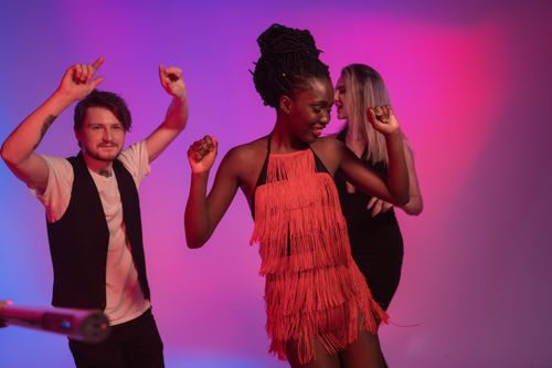 Free Group of young adults dancing energetically in a vibrant club setting. Stock Photo