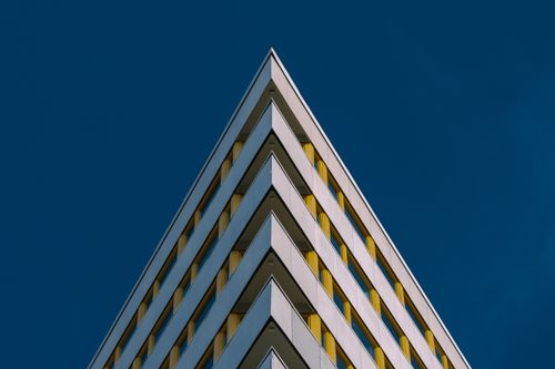 Free Striking view of a modern high-rise building with geometric design against a clear blue sky. Stock Photo