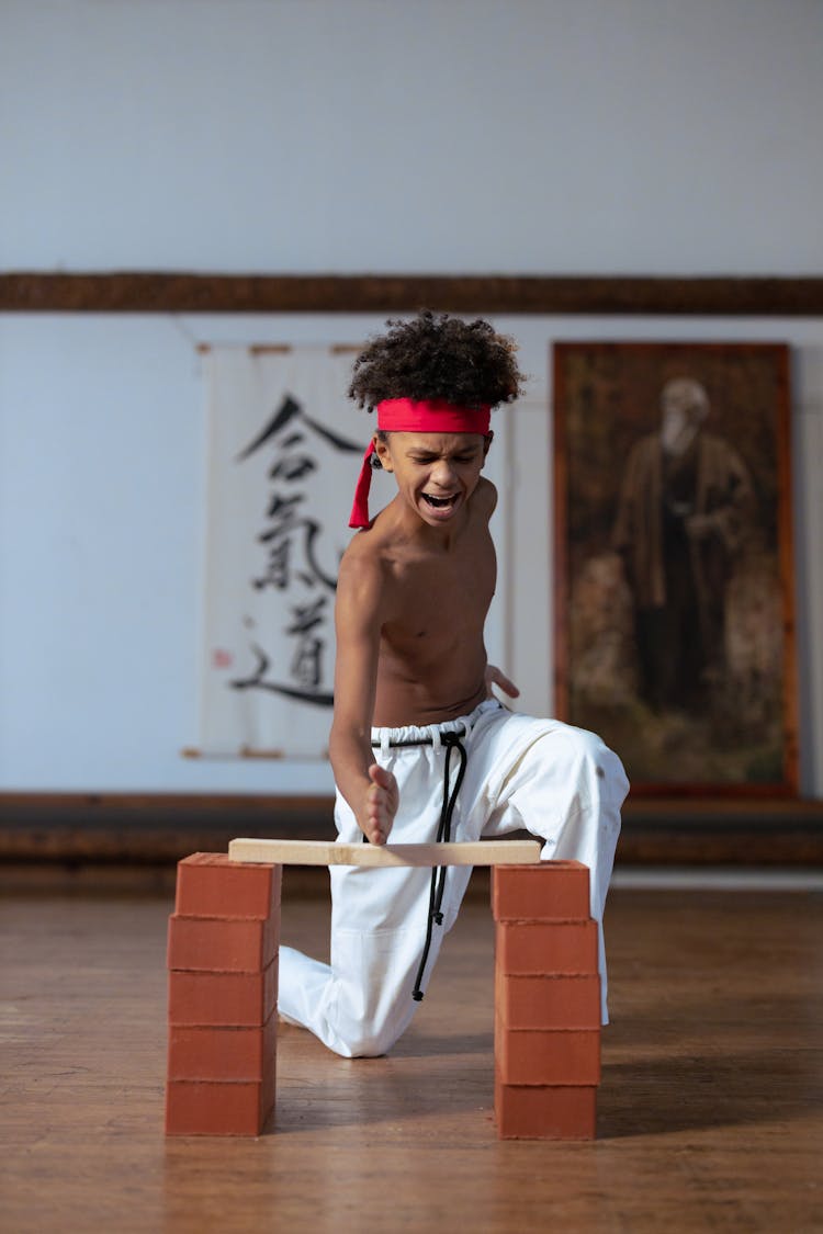 A Boy Breaking A Board In Karate