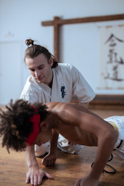 
A Man Training a Shirtless Boy