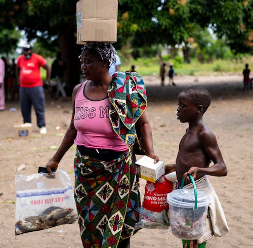 Free Mother and Son Carrying Relief Goods Stock Photo