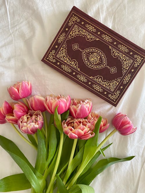 Free A Brown Book and Pink Tulips on White Textile Stock Photo