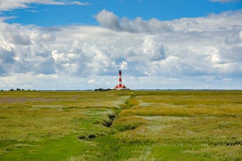 Free Landscape Scenery of an Open Field Across the Lighthouse Stock Photo