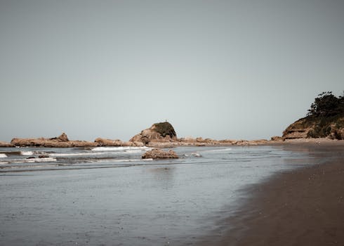 Serene coastal landscape featuring rock formations and beach at low tide near Port Angeles.