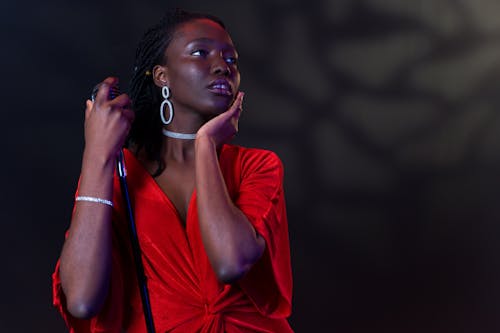 A Woman Singing Emotionally while Holding Her Microphone