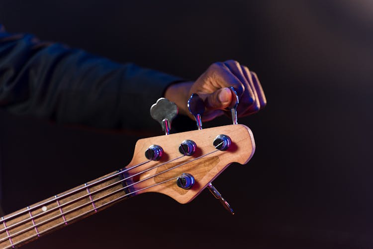 Close-Up Shot Of A Person Tuning A Guitar