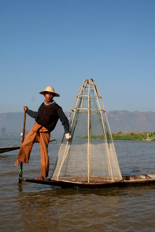 A Fisherman Standing on a Boat