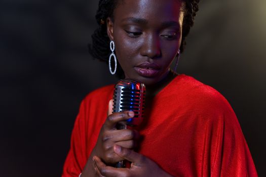 Close-up of an emotional singer holding a microphone in a dramatic setting.
